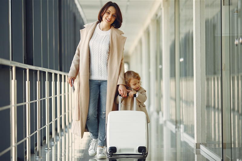 空港を歩いている母と幼い娘のイメージ画像
